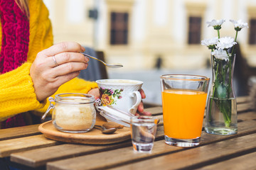 Woman having coffee with brown sugar at outdoor cafe