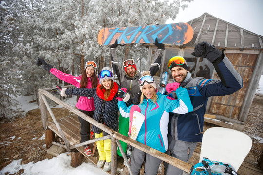 Group of snowboarders in winter wooden house