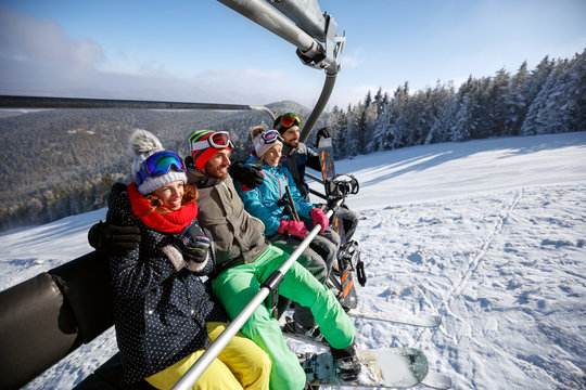Skiers in ski lift lifting on ski terrain