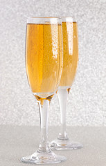 Glasses of Champagne on a Silver Glitter Backdrop