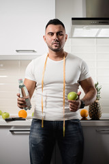 male nutritionist keeps a bottle of water and an apple in the kitchen