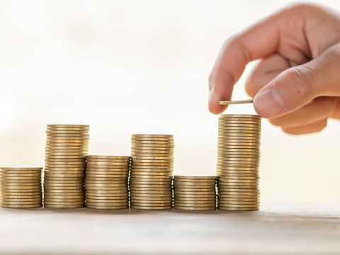 save money and investment concept with coin stack growing graph selective focus. Invest your money to get in come,growing business and future concept