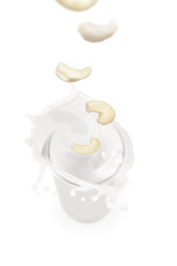 cashew  falling into a glass of milk with splashes