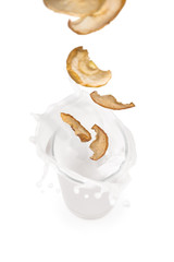 dried apples  falling into a glass of milk with splashes