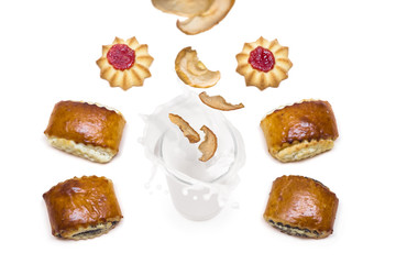 dried  apples falling into a glass of milk with splashes around which are tasty cookies