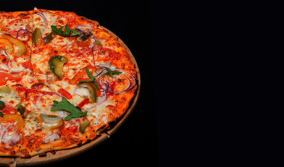 Pizza on a wood board on a black background