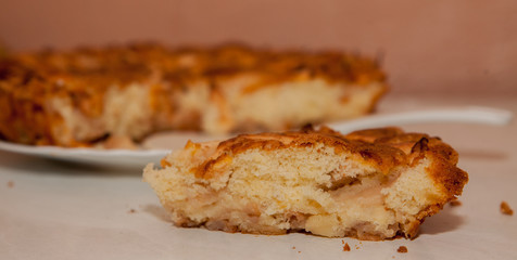 Fresh slice of apple pie with whole pie in background