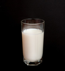 a glass of milk on a black background