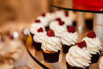 Delicious cupcakes with berries on festive table close up