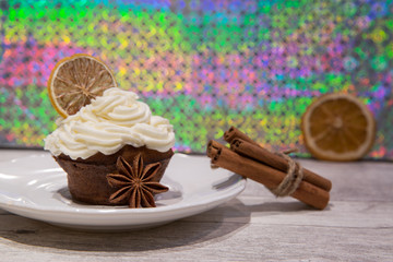Christmas muffins with mascarpone frosting, dried citrus, orange, lemon and lime decoration, cinnamon rolls and anise stars. Bright colorful background.