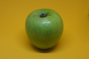 Fresh green apple with yellow background