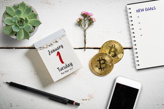 Tear-off calendar with 1st of January 2019 on top, surrounded by bitcoins and other decorative elements
