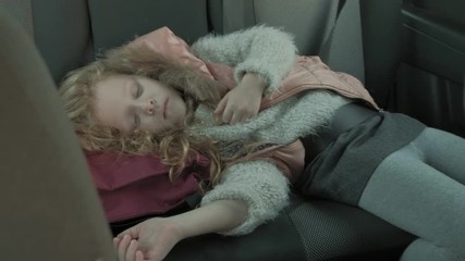 the little girl was sleeping in the car in the back