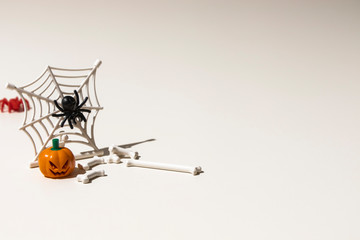 Composition of plastic toys for Halloween, with pumpkin, spider, cobweb, snake and bones