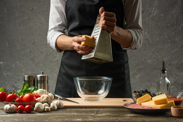 Rubbing mozzarella cheese chef cook for pasta, Italian pizza. The concept of food