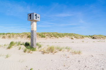 Beach post on sand against blue sky, IJmuiden, Netherlands