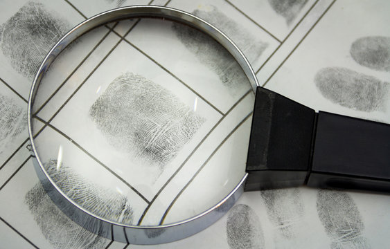 The investigation of the crime. A fingerprints and magnifying glass on a paper