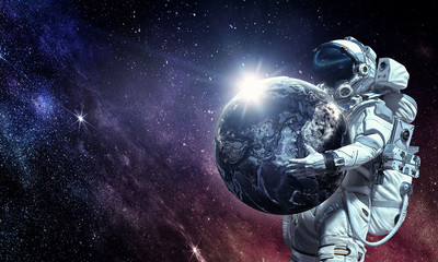 Obraz na płótnie Canvas Spaceman carry big planet. Mixed media