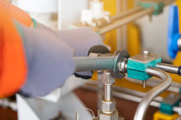 A mechanic operator fix and tighten stainless steel tubing system by using combination wrench, offshore oil and gas industry maintenance and service business