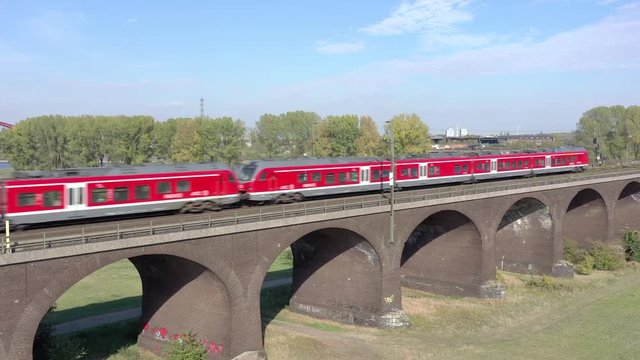 Commuter Train Crossing a Brick Bridge