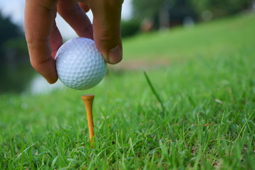 Golf ball and tee on golf green course background