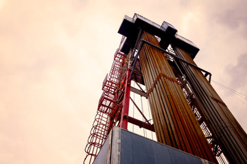 Oil and Gas Drilling Rig onshore dessert with dramatic cloudscape. Oil drilling rig operation on...