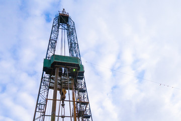 Oil and Gas Drilling Rig onshore dessert with dramatic cloudscape. Oil drilling rig operation on the oil platform in oil and gas industry.