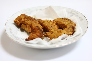 Deep fried chicken breast fried on a white plate.