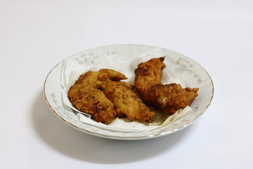 Deep fried chicken breast fried on a white plate.