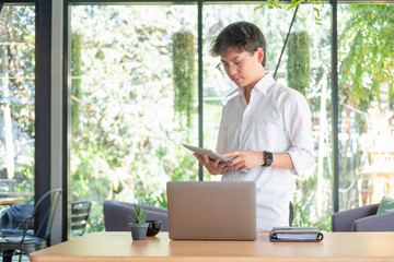 Fototapeta premium young business man working with mobile laptop and documentsin office, business concept