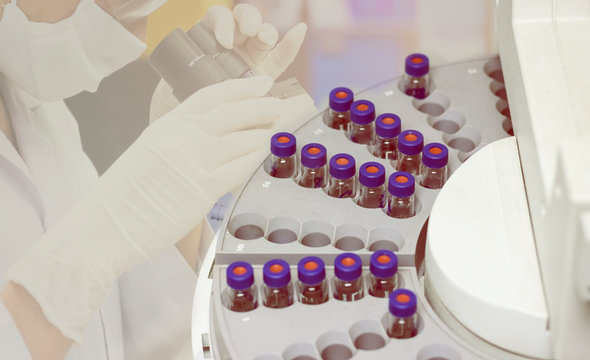 Top view of vials are arranged in the auto sampler for GC chromatography in laboratory with microscope tesing background