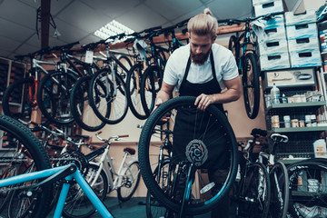 Young Mechanic Repairs Bicycle in Bike Workshop
