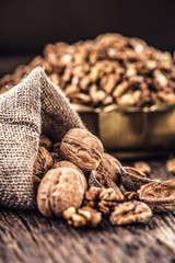 Walnut kernels whole walnuts in burlap sack and vintage bowl