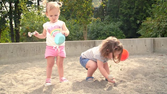 Little Girl Friends Getting Dirty at Park Sand Pit