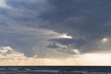 Fototapeta premium Rain clouds over Baltic sea near shoreline just before sunset, selective focus