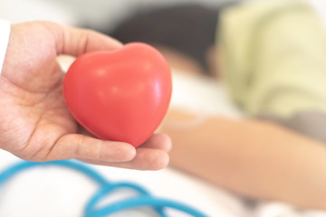 Hospital care concept. Digital patient observation chart on computer laptop with blue medical doctor stethoscope and heart shape on wooden background.