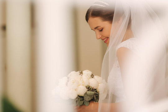 Young and tenderness bride in wedding dress hold bouquet. Happy bride in her wedding day