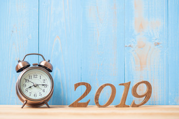 2019 Happy New years with retro alarm clock and wooden number  on table and copy space. New Start, Resolution, Goals and Mission Concept