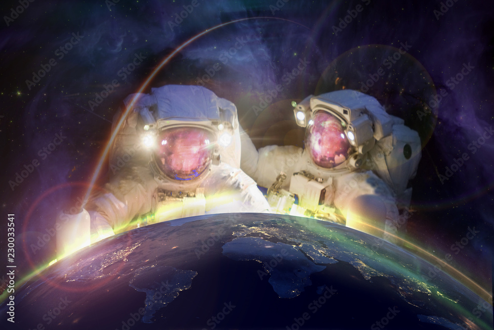 Poster two huge astronauts look at planet earth from space against the background of the galaxy. elements o
