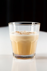 Glass of white russian cocktail at white background.