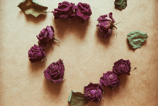  wilted roses on a wooden background with blank space