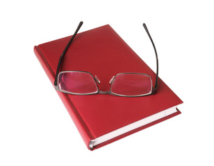 Glasses lying on a red notebook isolated on white background