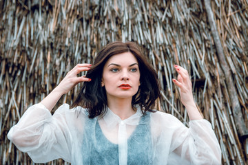 Portrait of a girl in white clothes on a background of hay.