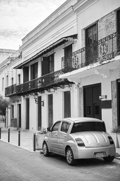 Reportage photos of building facades and cars parked near buildings on the streets of Santo Domingo the capital of Dominican Republic. Buildings are situated in colonial zone of old city.