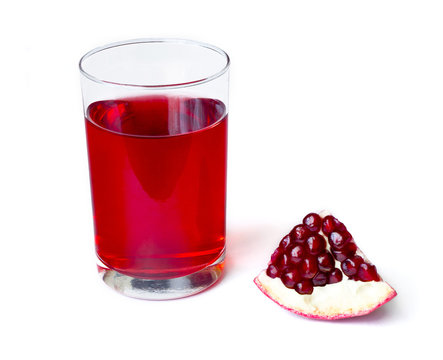 Fresh pomegranate juice in a glass beaker and sliced pomegranate slice isolated on white background
