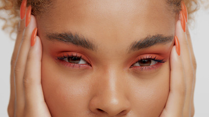 mixed race black blonde model with curly hair macro closeup of eyes with red makeup