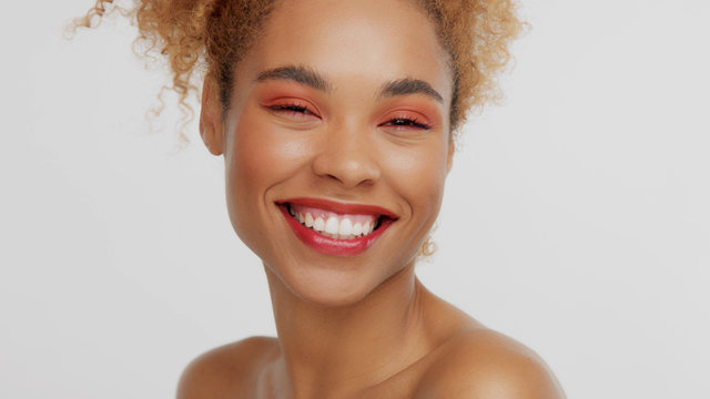 closeup portrait of mixed rase woman with red makeup in studio happy laughing smiling