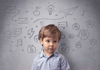 Smart little junior in front of a drawn up grey wall with childlike concept