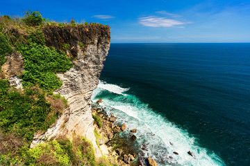 Azure beach with rocky mountains and clear water of Indian ocean at sunny day / A view of a cliff in Bali Indonesia / Bali, Indonesia