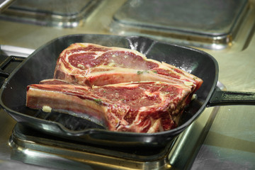 Raw fresh meat T-bone steak on grill iron pan